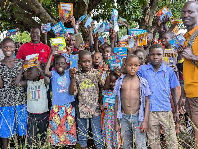 Children and community members holding up books together